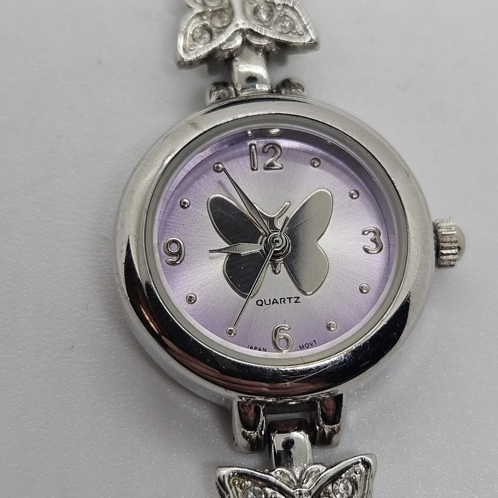 small silver tone watch with purple face and rhinestone butterflies